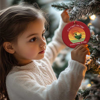 Child holding a red round Christmas ornament with skeleton fire graphic and gold loop