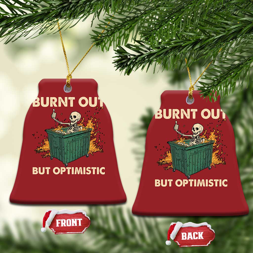 Two red bell-shaped Christmas ornaments with skeleton dumpster art and “Burnt out, but optimistic”.