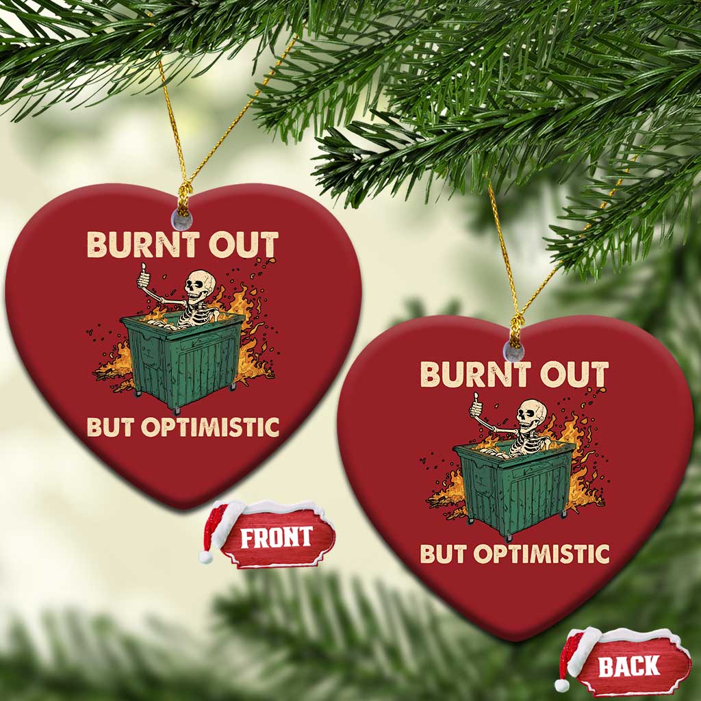 Two red heart-shaped Christmas ornaments with skeleton dumpster art and “Burnt out, but optimistic”.