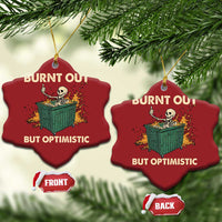 Two red heart-shaped Christmas ornaments with skeleton in a dumpster and “Burnt out, but optimistic”.
