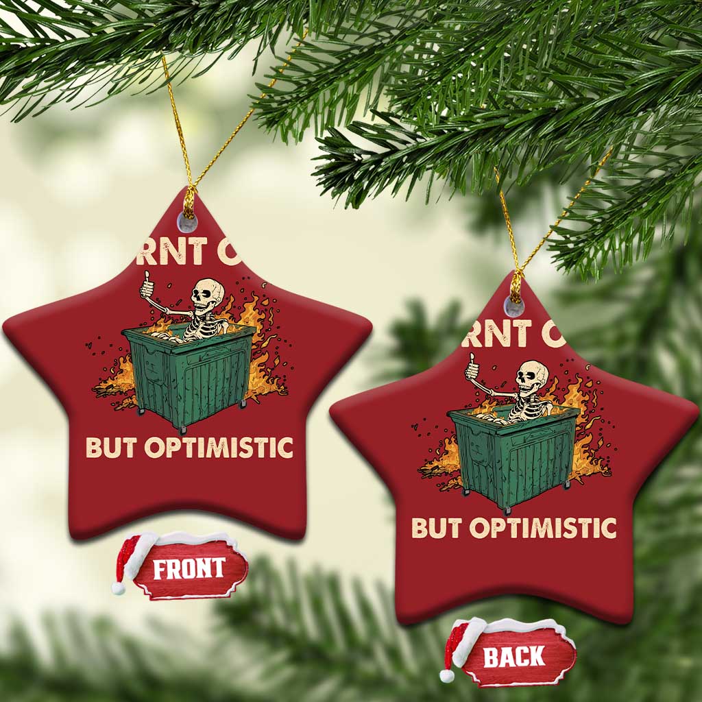 Two red star-shaped Christmas ornaments with skeleton dumpster graphic and “Burnt out, but optimistic”.