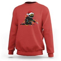 Red crewneck sweatshirt with holiday cat graphic in colorful string lights