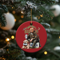 Red round Christmas ornament hanging from pine branch with printed portrait of man and dog.