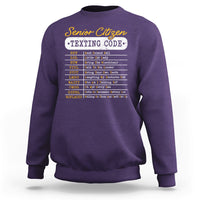 Purple crewneck sweatshirt with “Senior Citizen Texting Code” front graphic
