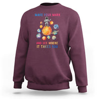Maroon crewneck sweatshirt with space astronaut graphic on back