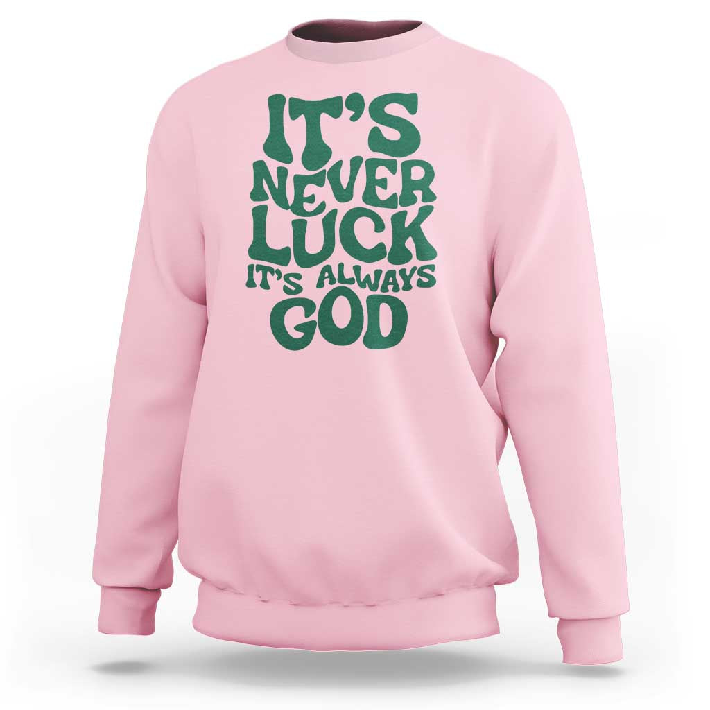 Pink crewneck sweatshirt with green "It's Never Luck" "It's Always God" text graphic