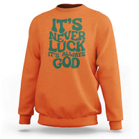 Orange crewneck sweatshirt with dark "It's Never Luck" "It's Always God" text graphic