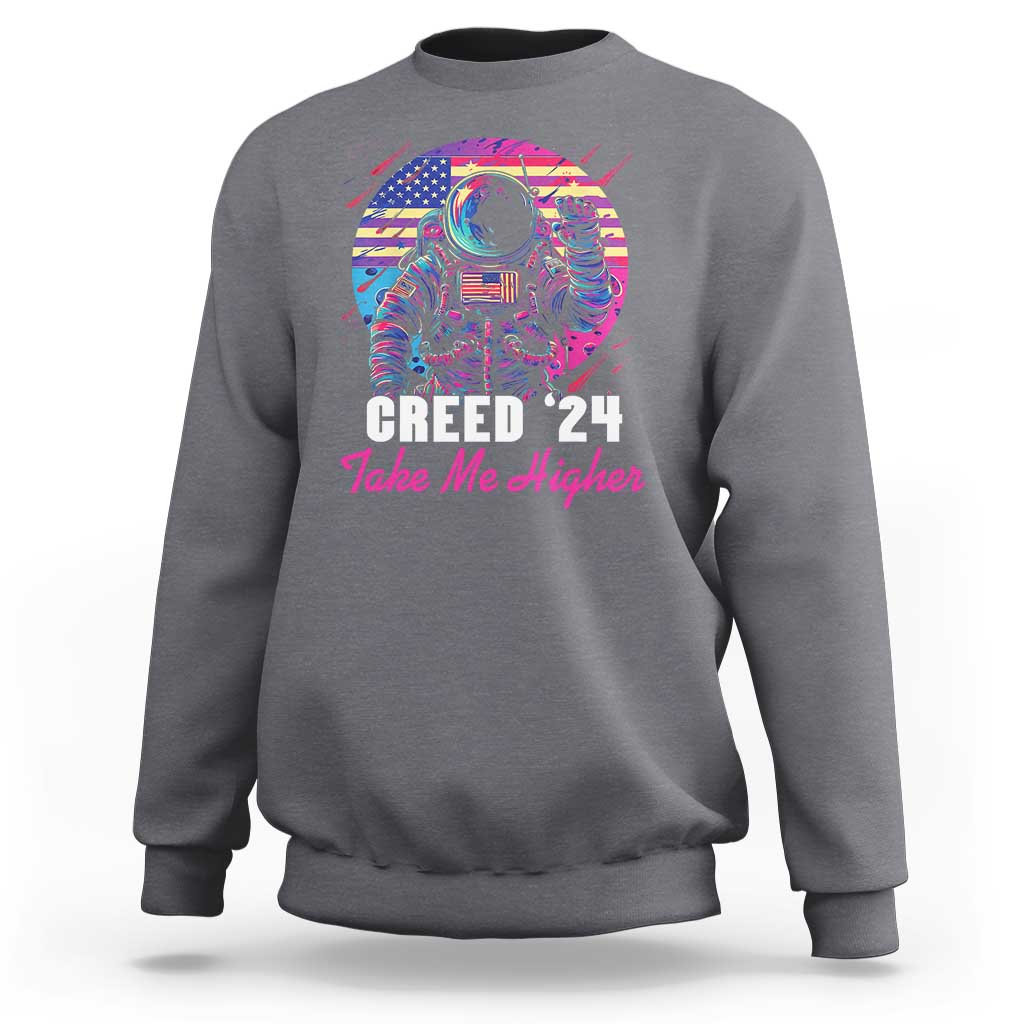Dark heather crewneck sweatshirt with astronaut graphic and “Creed ’24 Take Me Higher” text