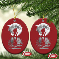 Two red oval Bigfoot Christmas ornaments with silver moon and reflection, gold loops