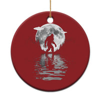 Red circular Bigfoot Christmas ornament with silver moon and reflection, gold hanging loop