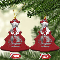 Two red Christmas tree-shaped Bigfoot ornaments with silver moon and reflection