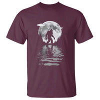 Maroon t-shirt with Bigfoot silhouette under moon and rippling water reflection print.