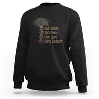 Black crewneck sweatshirt with multicolor tree graphic and “Our Roots Run Deep” text