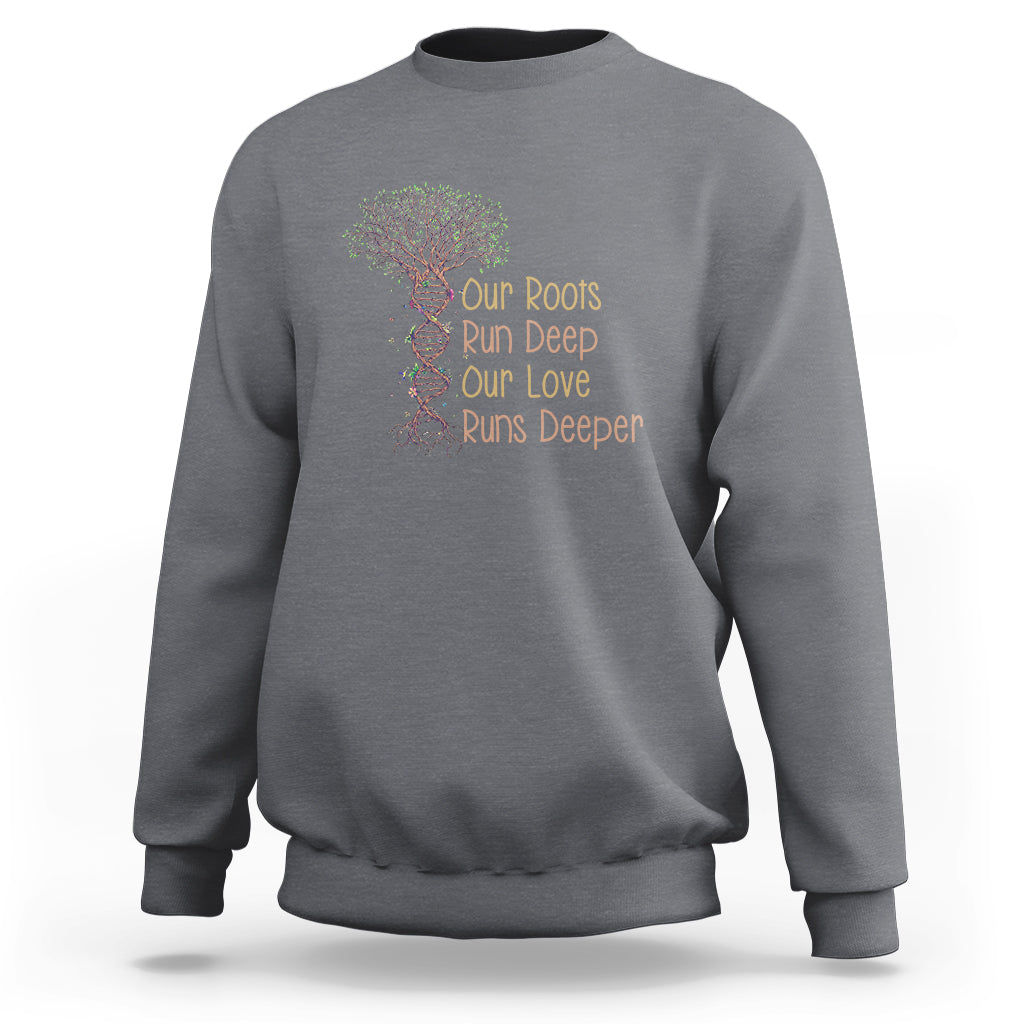 Charcoal gray crewneck sweatshirt with multicolor tree graphic and “Our Roots Run Deep” text