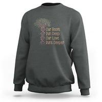 Dark heather gray crewneck sweatshirt with multicolor tree graphic and “Our Roots Run Deep” text