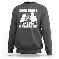 Dark gray crewneck sweatshirt with “Soon Under New Management” graphic and silhouettes.
