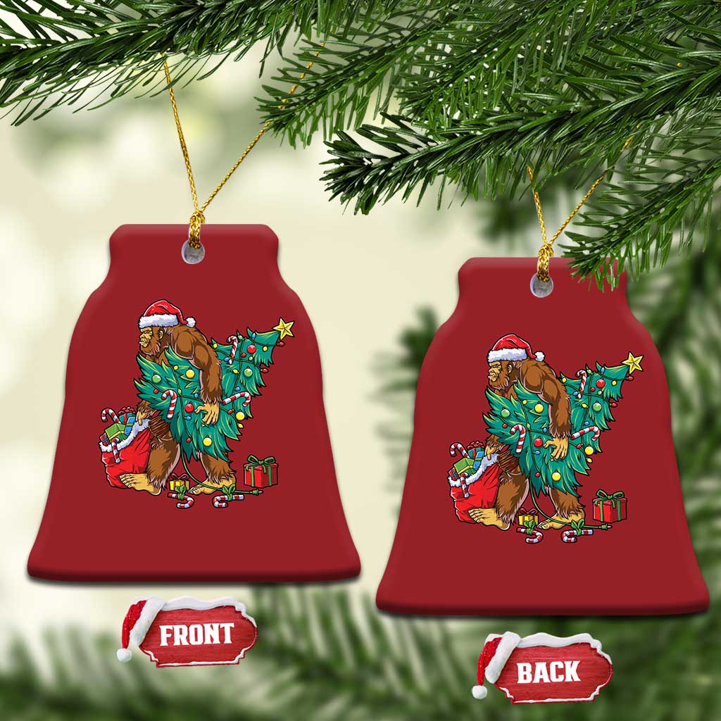 Two red bell-shaped Bigfoot Christmas ornaments with Santa hat, decorated tree and gift boxes