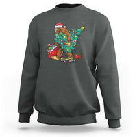 Dark heather Bigfoot Christmas sweatshirt with tree lights, gifts, and candy cane graphic