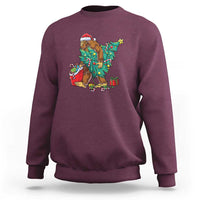 Maroon Bigfoot Christmas sweatshirt with tree lights, gifts, and candy cane graphic