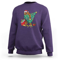 Purple Bigfoot Christmas sweatshirt with tree lights, gifts, and candy cane graphic