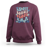 Maroon crewneck sweatshirt with colorful 'Bonus Mom' graphic on chest