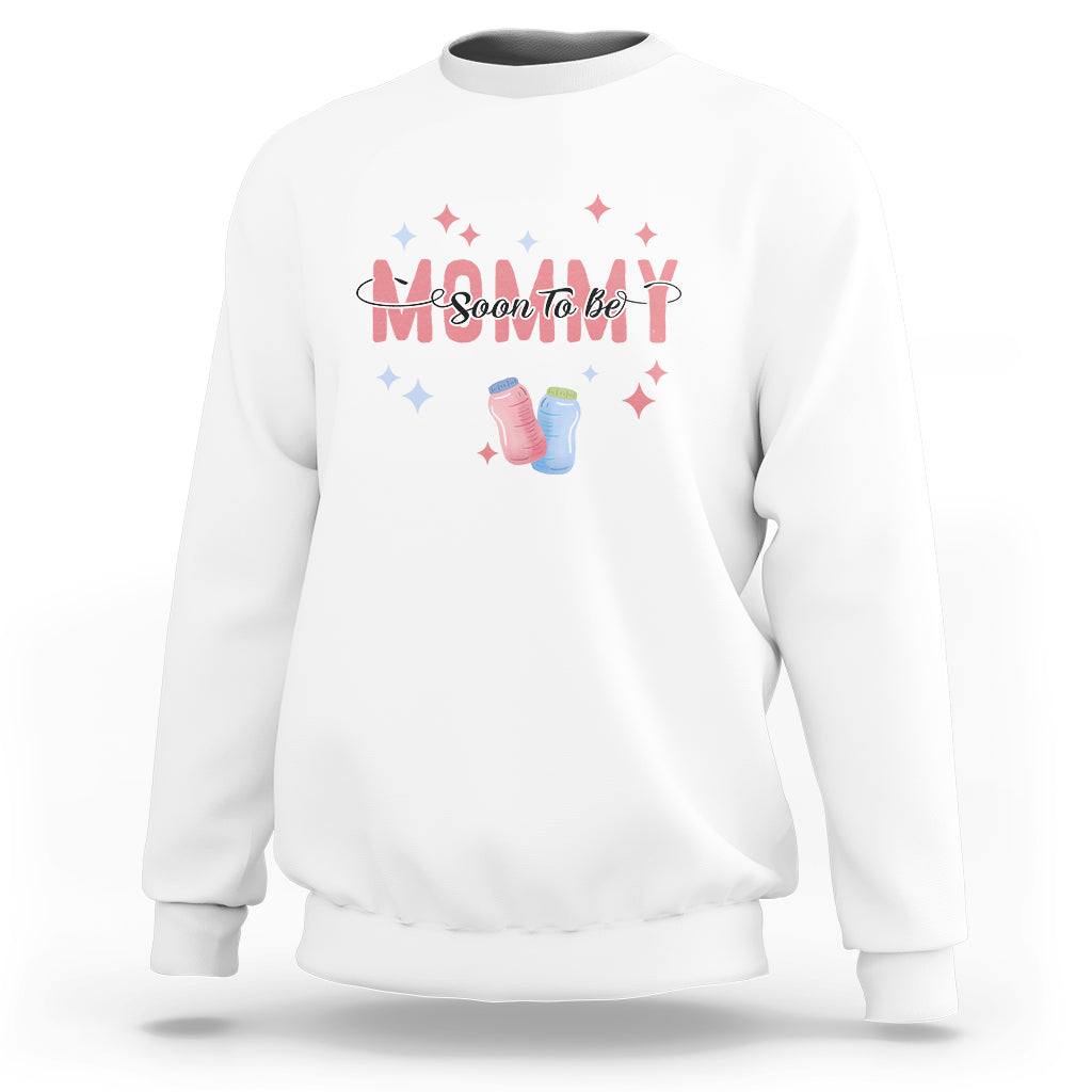 White maternity sweatshirt with “Soon To Be” graphic, baby shoes, and star accents