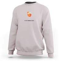 Light gray crewneck sweatshirt with small orange drink graphic and “IN MY SPRITZ ERA” text