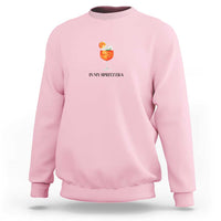 Light pink crewneck sweatshirt with small orange drink graphic and “IN MY SPRITZ ERA” text
