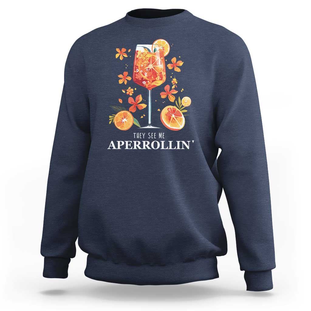 Navy sweatshirt with front citrus cocktail graphic and “They see me APERROLLIN’” text