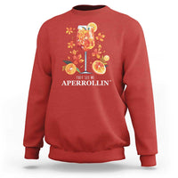 Red sweatshirt with front citrus cocktail graphic and “They see me APERROLLIN’” text
