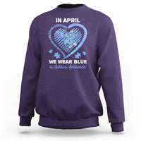 Purple crewneck sweatshirt with 'In April' heart graphic and slogan on back.