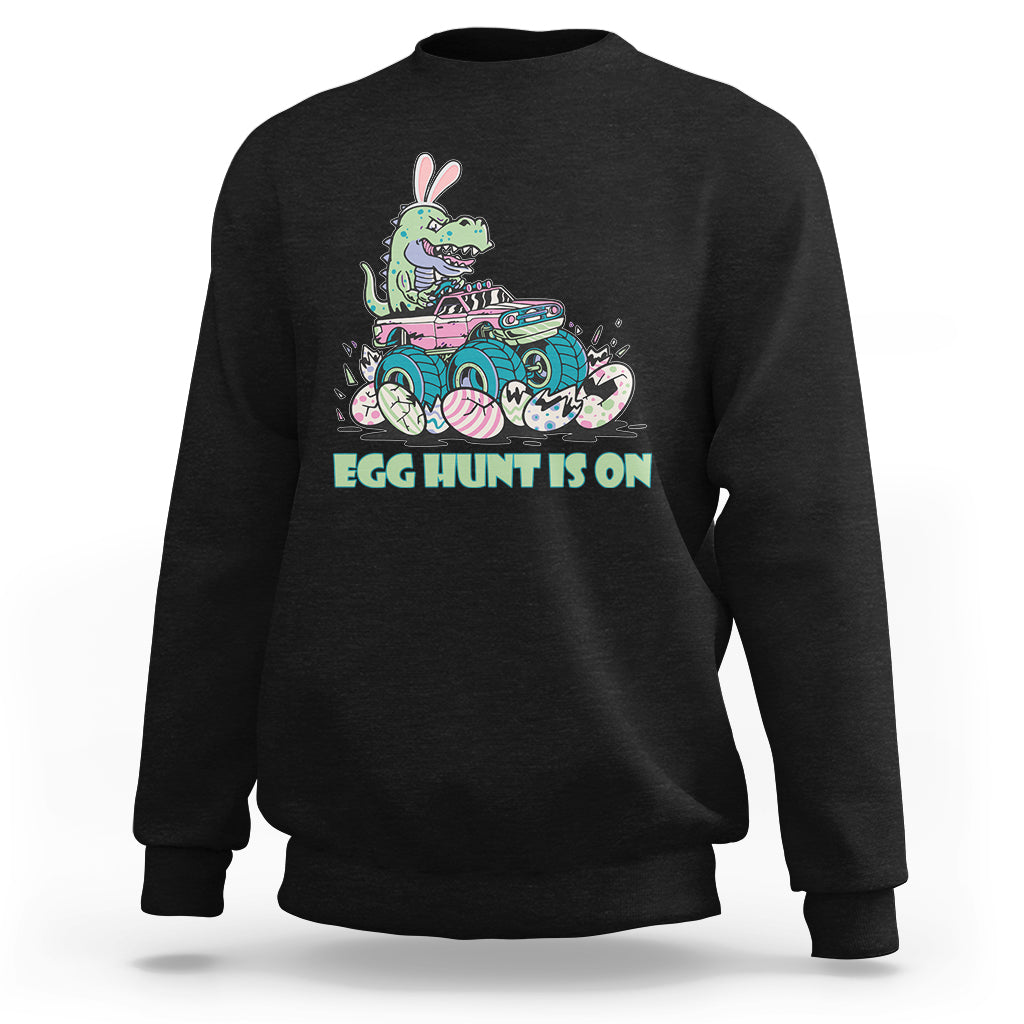 Kids' crewneck sweatshirt in black with Easter dinosaur-bunny graphic, 'EGG HUNT IS ON'.