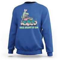 Kids' crewneck sweatshirt in royal blue with Easter dinosaur-bunny graphic, 'EGG HUNT IS ON'.
