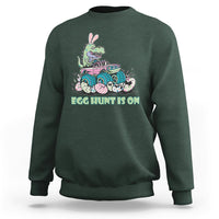 Kids' crewneck sweatshirt in forest green with Easter dinosaur-bunny graphic, 'EGG HUNT IS ON'.