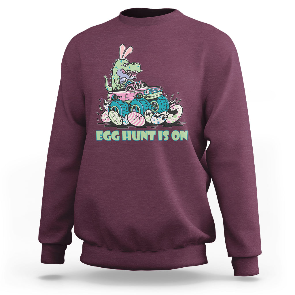Kids' crewneck sweatshirt in maroon with Easter dinosaur-bunny graphic, 'EGG HUNT IS ON'.