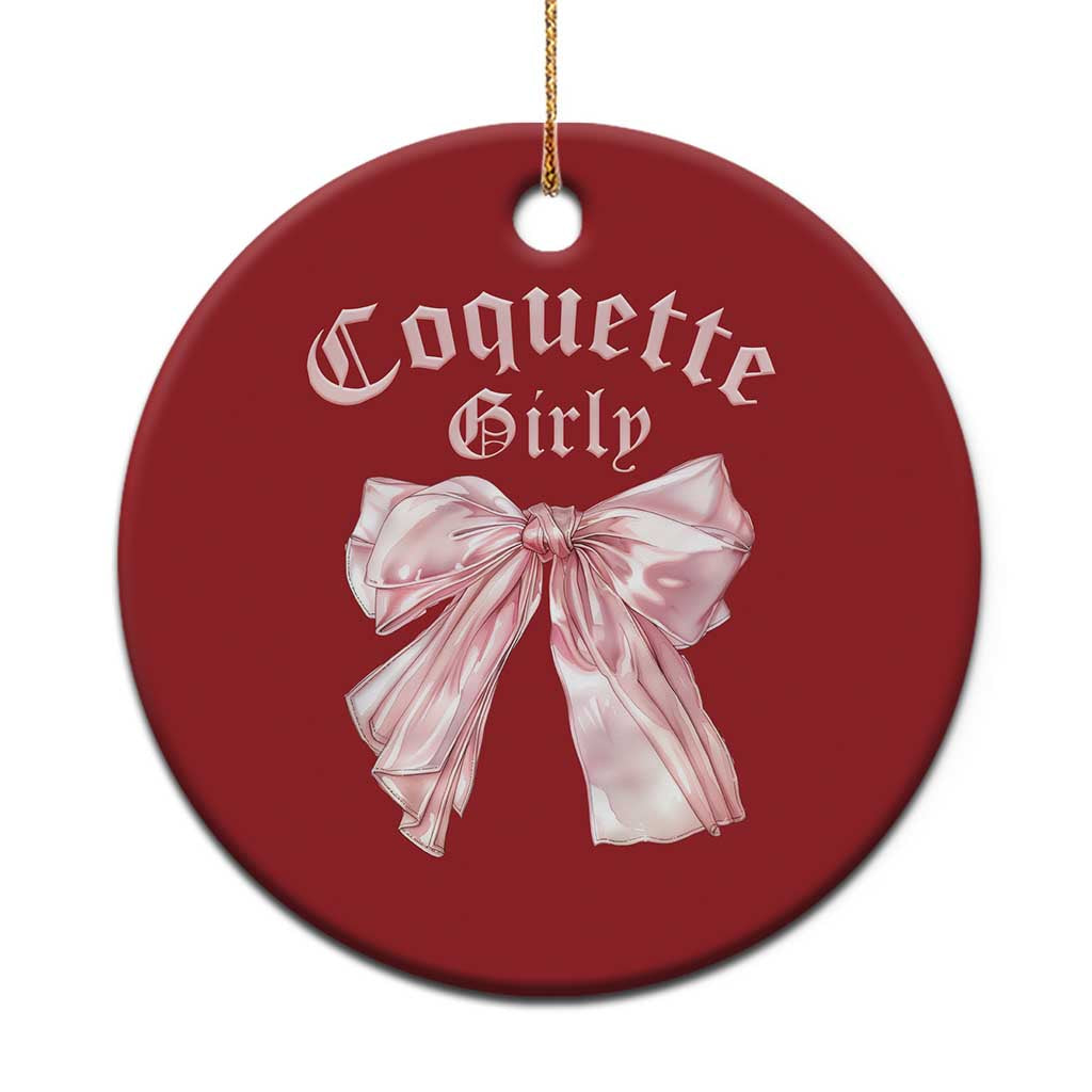 Red circular Christmas ornament with pink bow and gold hanging string