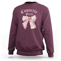 Maroon crewneck sweatshirt with pink bow graphic on chest, ribbed cuffs and hem.