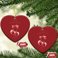 Two red heart-shaped ornaments with pink ribbon bow and two cherry charms on gold hooks