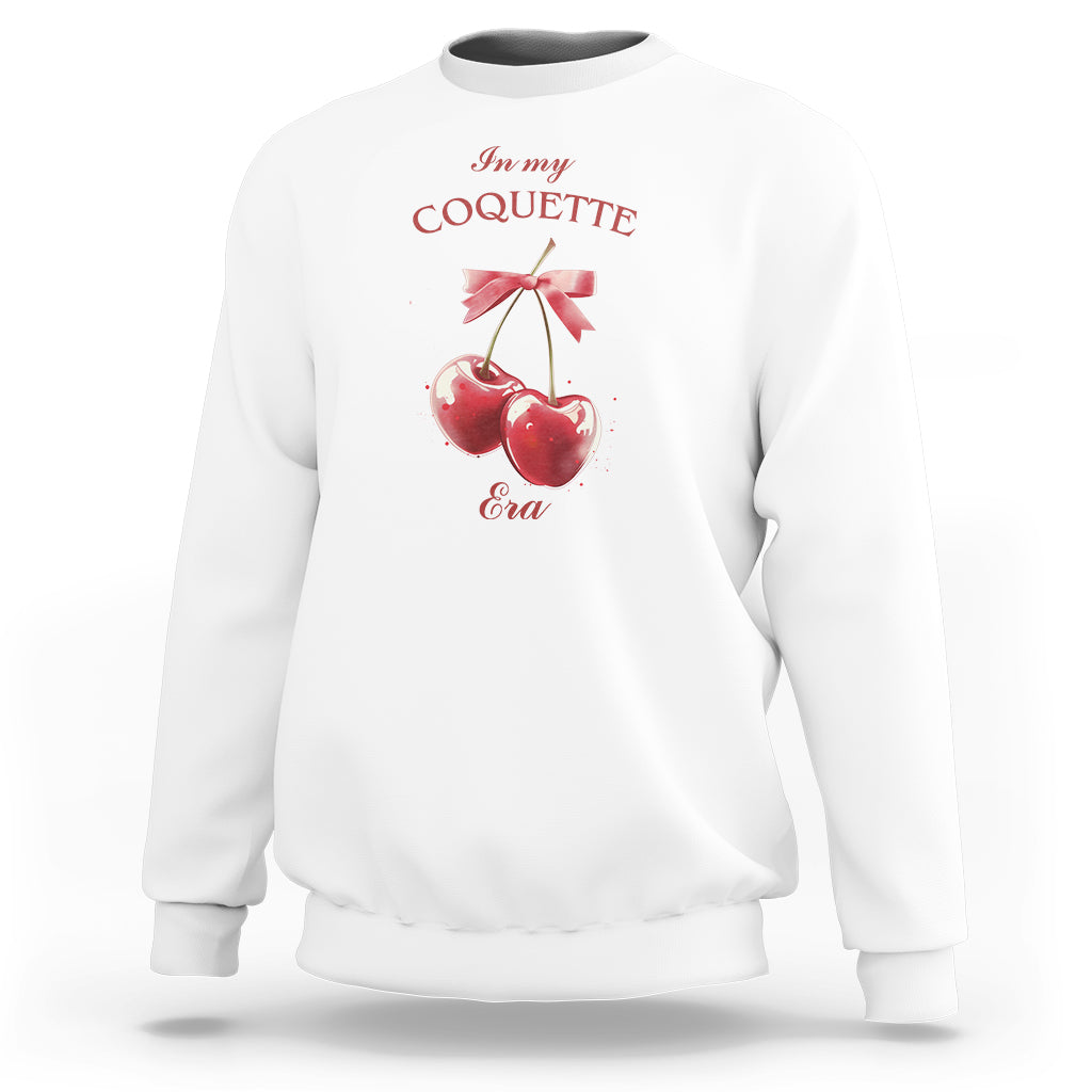 White sweatshirt with cherry and bow graphic at chest, crew neck
