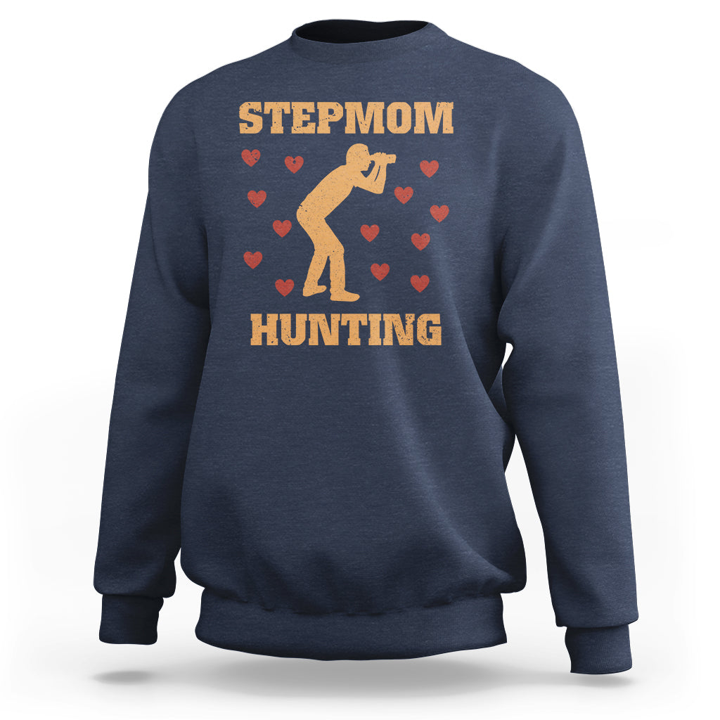 Blue crewneck sweatshirt with “STEPMOM HUNTING” graphic and dog silhouette with hearts