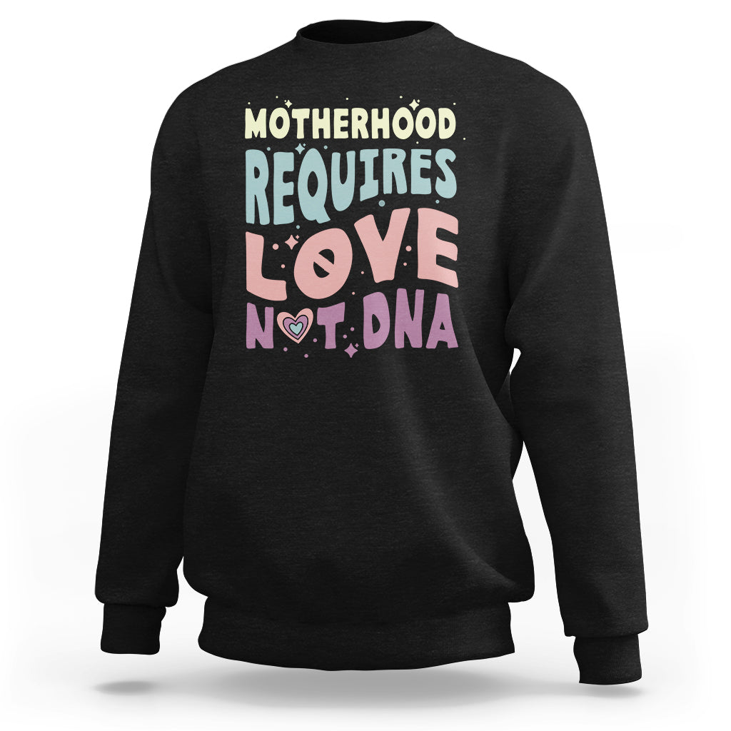 Black crewneck sweatshirt with 'Motherhood requires love not DNA' front graphic