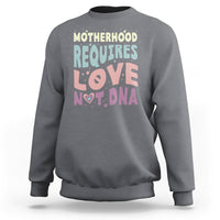 Dark heather crewneck sweatshirt with 'Motherhood requires love not DNA' front graphic