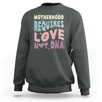 Charcoal crewneck sweatshirt with 'Motherhood requires love not DNA' front graphic
