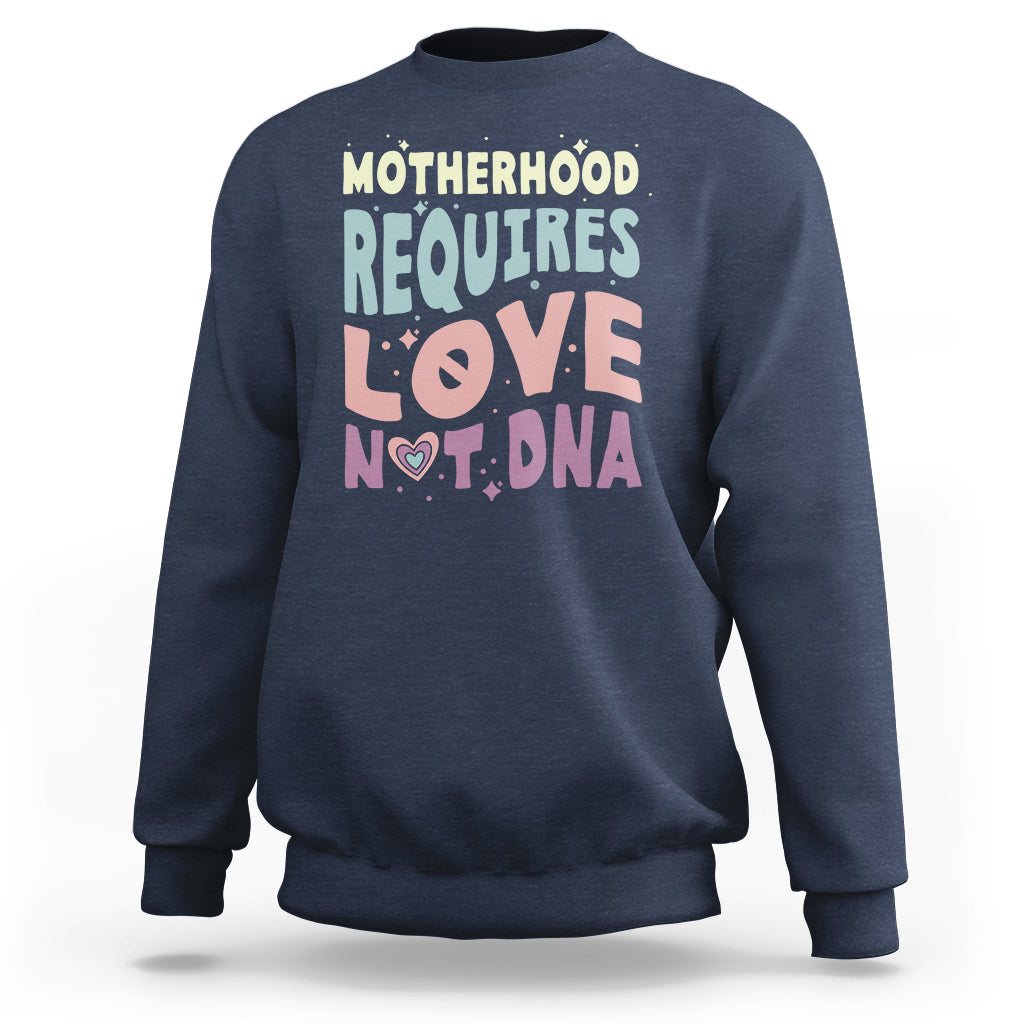 Navy crewneck sweatshirt with 'Motherhood requires love not DNA' front graphic