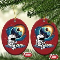 Two red oval astronaut space ornaments with cartoon astronaut and glowing planet