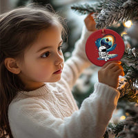 Red round astronaut space ornament hanging from a Christmas tree branch