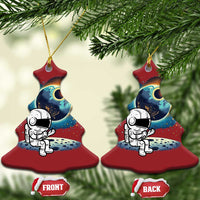 Two red Christmas-tree shaped astronaut space ornaments with cartoon astronaut and planet