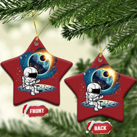 Two red star-shaped astronaut space ornaments with cartoon astronaut and planet glow