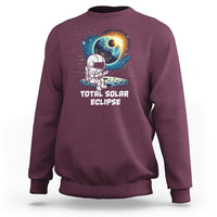 Maroon crewneck sweatshirt with astronaut eclipse front graphic