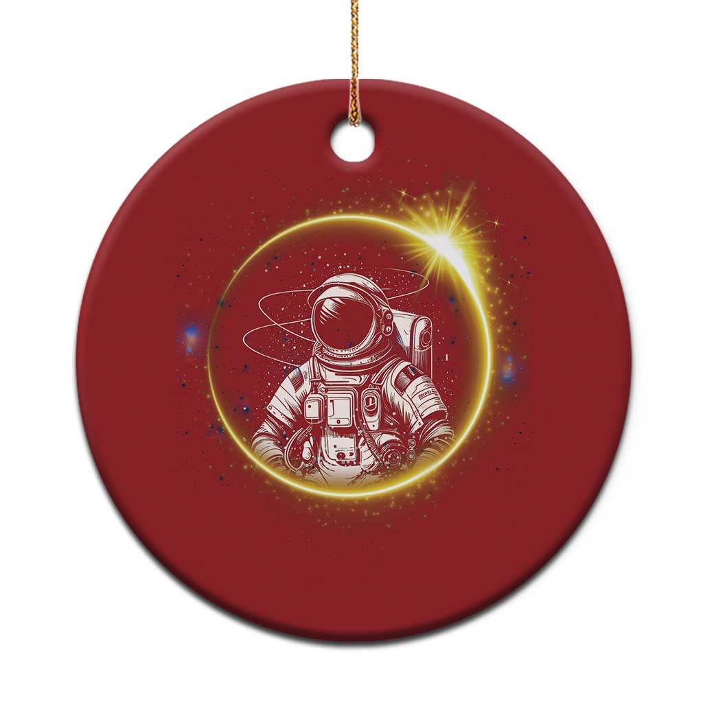 Red round astronaut Christmas ornament with glowing space scene and hanging gold string